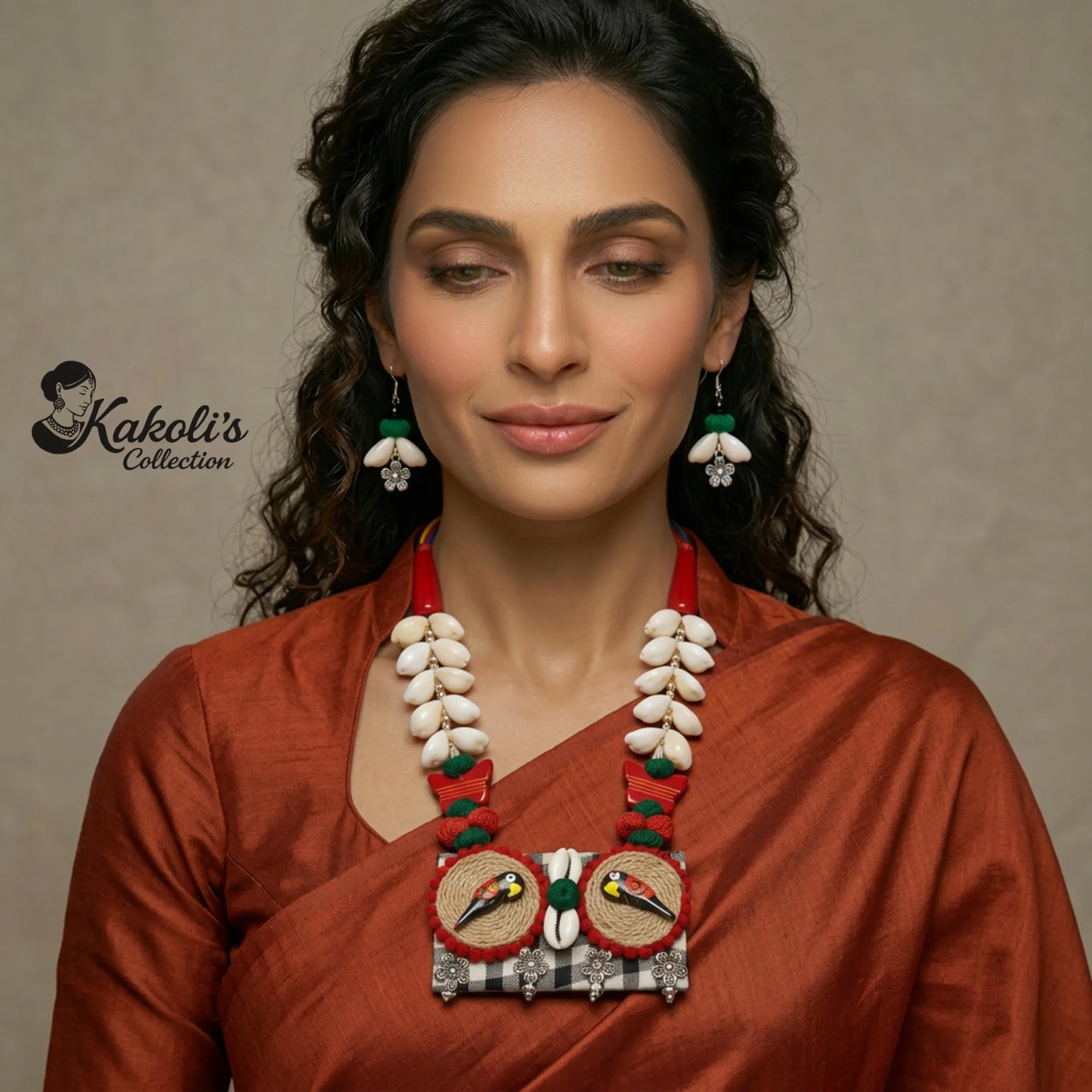 Woman wearing a traditional necklace the Bohemian Parrot and Cowrie Shell Handmade Fabric Necklace Set, featuring the Kakoli's Collection logo.