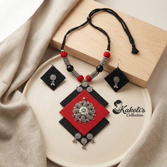 Crimson and Charcoal Geometric Handmade Fabric Necklace Set on a white plate, featuring red, black, and silver colors.
